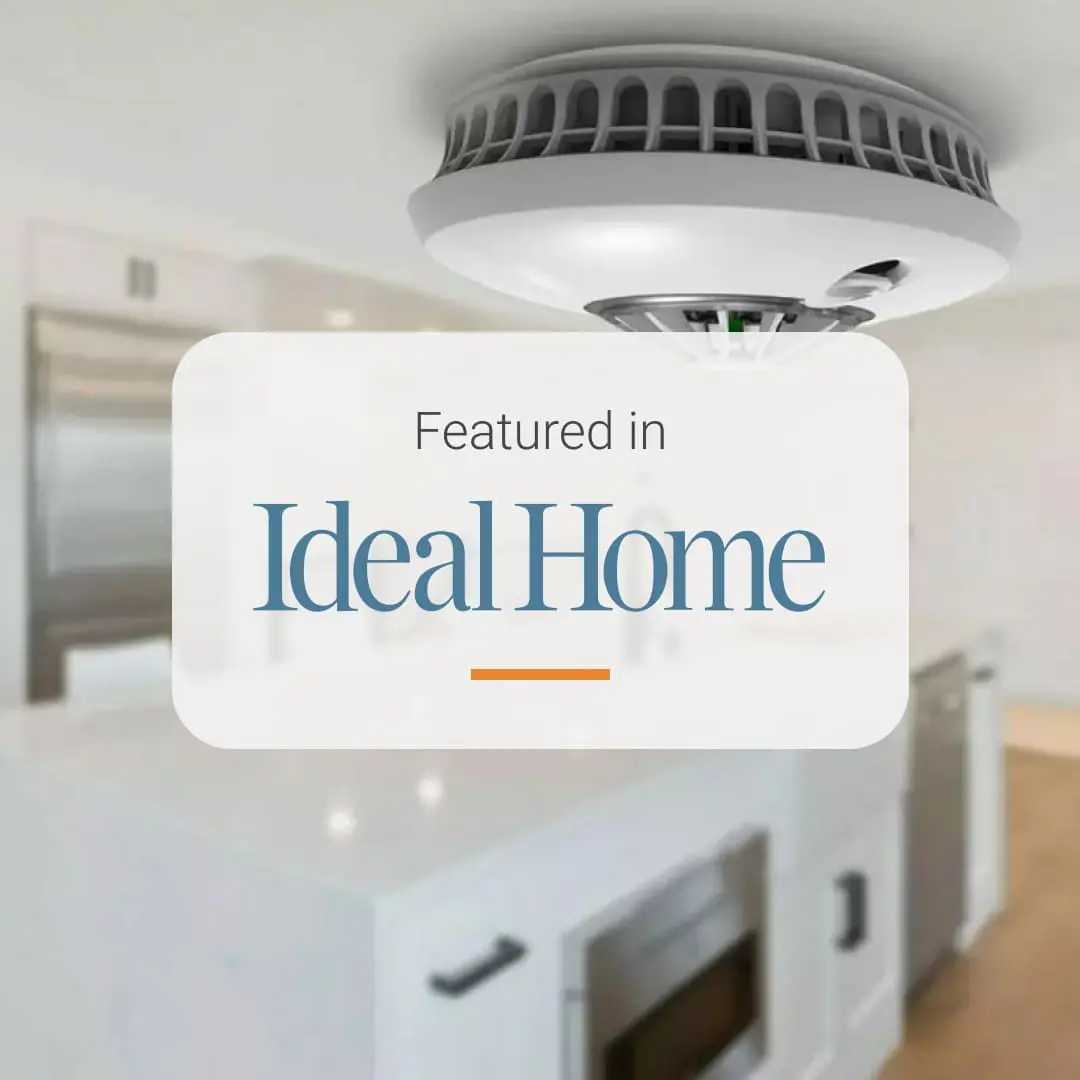 Kitchen with smart smoke detector and “Featured in Ideal Home” text overlay.