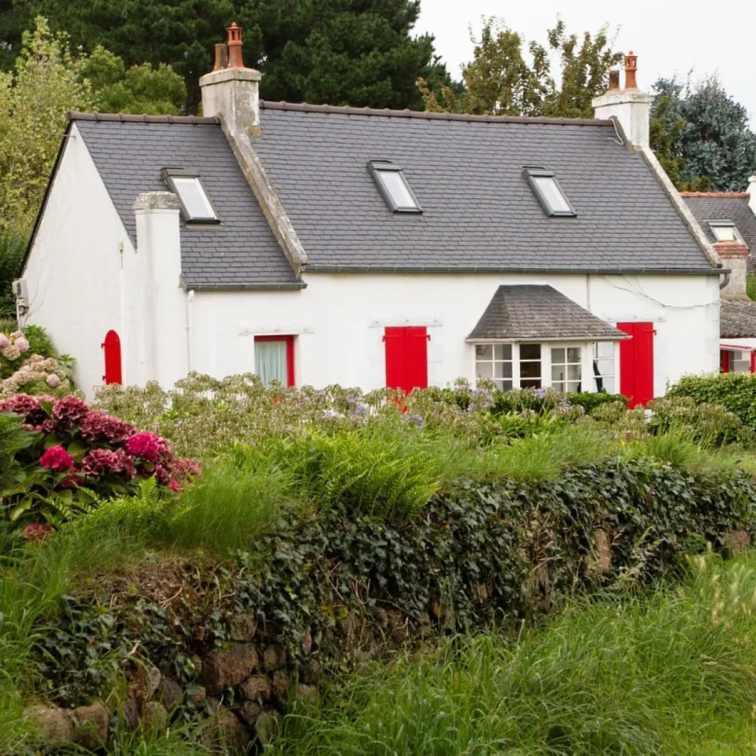 Charming white cottage with red shutters, fully compliant with holiday let regulations.