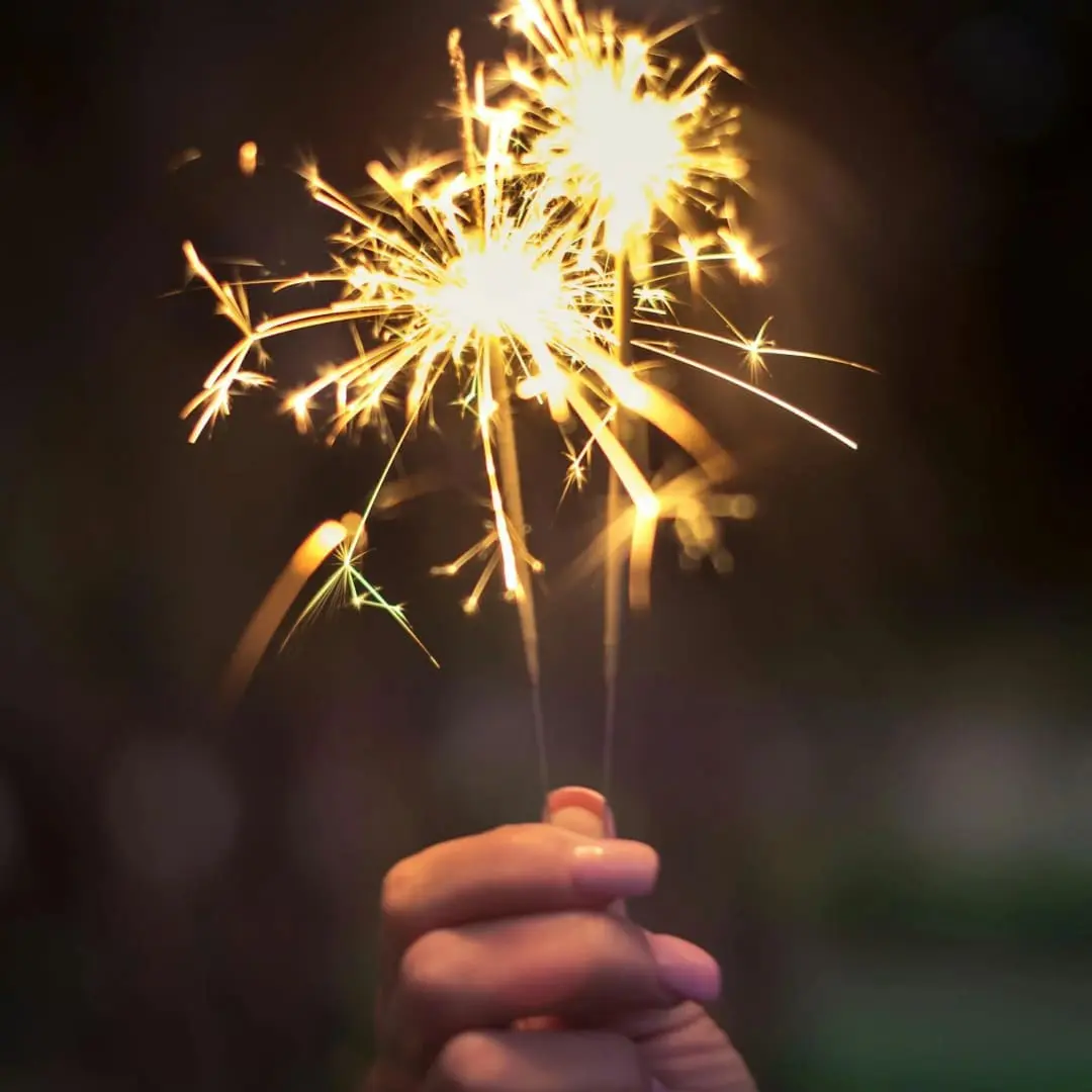 A hand holding a sparkler, celebrating with Bonfire Night safety 2023 in mind.