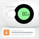 Close-up of an FA3322 CO alarm displaying 80% RH on its digital screen.