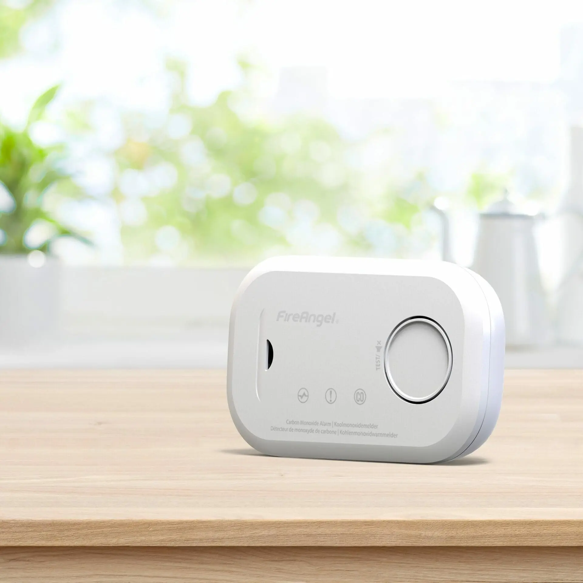 FA6813 carbon monoxide detector on wooden surface with blurred kitchen background.