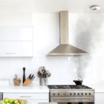 An FP1720W2-R emits black smoke while on the hob in a modern white kitchen.