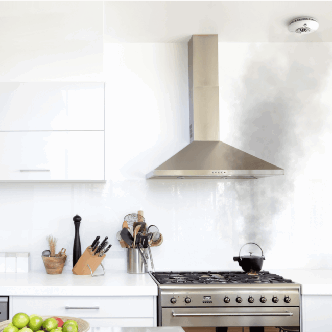 An FP1720W2-R emits black smoke while on the hob in a modern white kitchen.