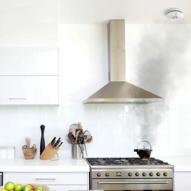 Black smoke rises from an FP1740W2-R pot on a hob in a bright modern kitchen.
