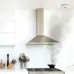 Smoke rises from a pot beneath the HM-SN-1 cooker hood in the kitchen.