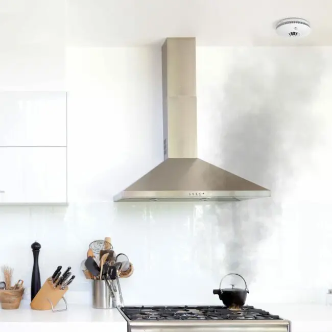 Smoke rises from a pot beneath the HM-SN-1 cooker hood in the kitchen.