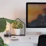 A modern desk with an HT-630, computer, potted plant, lamp, and keyboard.