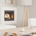 Modern living room with a fireplace, standard lamp, and FA3313x4 on a wooden coffee table.