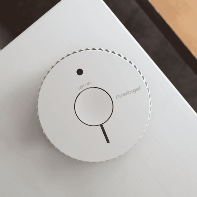Round white FA6615-R smoke detector mounted on a white ceiling, labelled FireAngel.