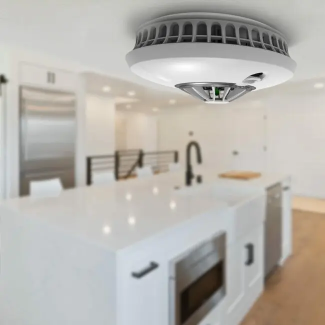 An HT-630 smoke detector is ceiling-mounted in a modern kitchen.