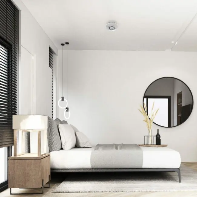 Minimalist bedroom with a low ST-750T bed, round mirror, and modern neutral décor.