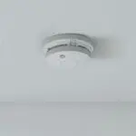 The SW1-PF-T smoke detector is mounted on a white ceiling.