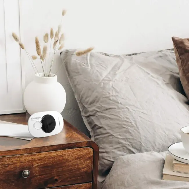FA3322 bedside table with vase, device, book, and cup beside a tidy bed.