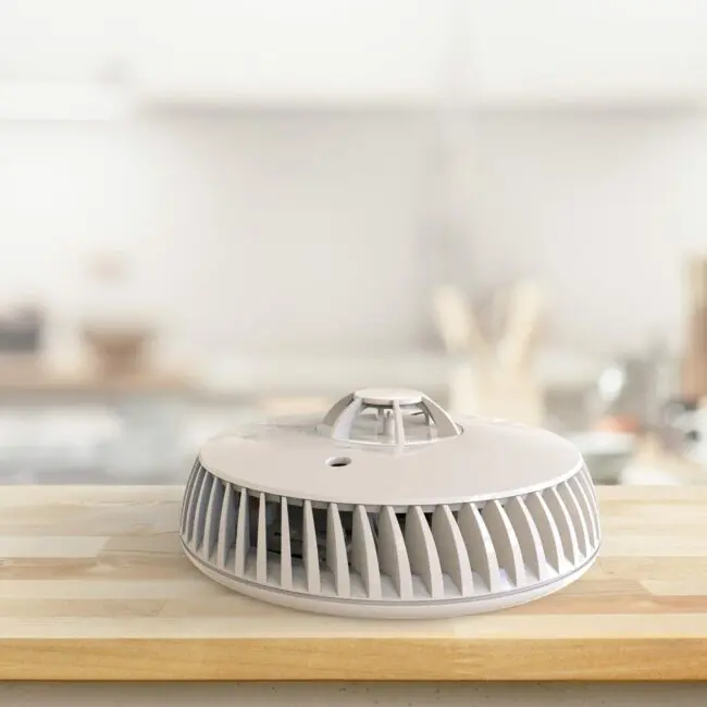 A white FA6720-R air purifier sits on a wooden kitchen worktop with a blurred background.