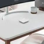 White desk with monitor, cup, coaster, and FP1000W2-R device in the centre.