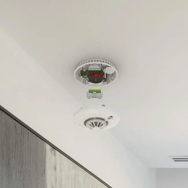 FP1720W2-R smoke detector on ceiling with cover off, showing internal components.