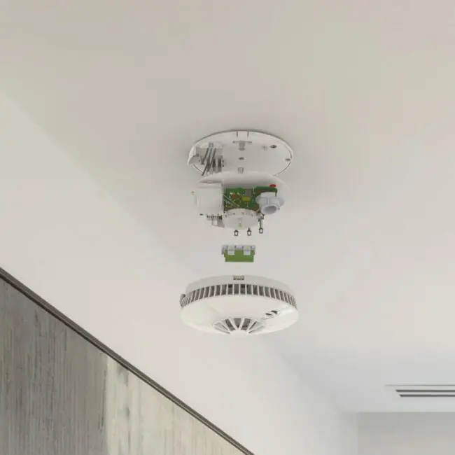 The FP1740W2-R smoke detector is on the ceiling with its cover and inner parts visible.