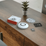 FP2620W2-R kit with box, manual, screws, and plant on a wooden cupboard.