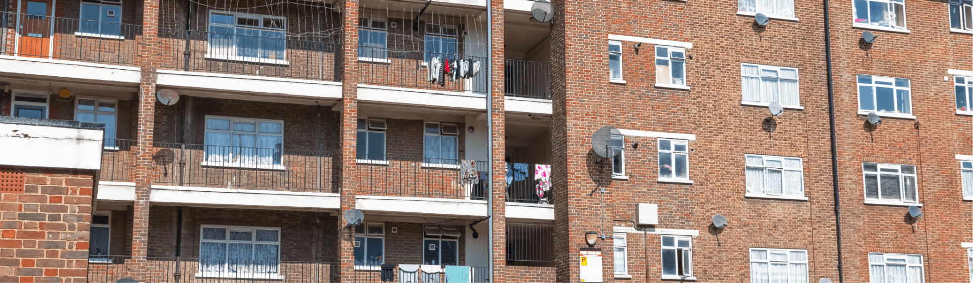 Brick block of flats with balconies, windows, and empowering residents under the Social Housing Act.