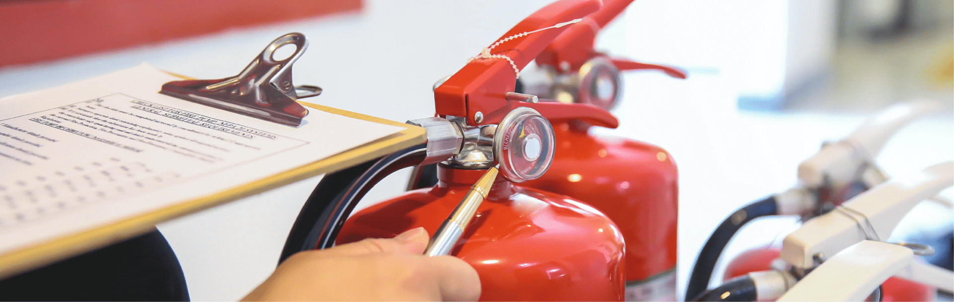 Hand inspecting a fire extinguisher, ensuring holiday let regulations are met.