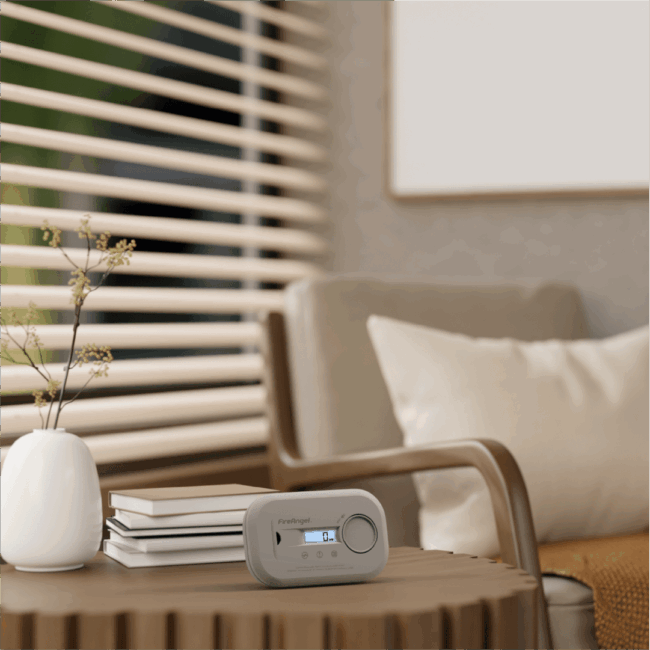 A compact FA6812-EUX10 device sits on a table near books in a cosy, neutral-toned living room.