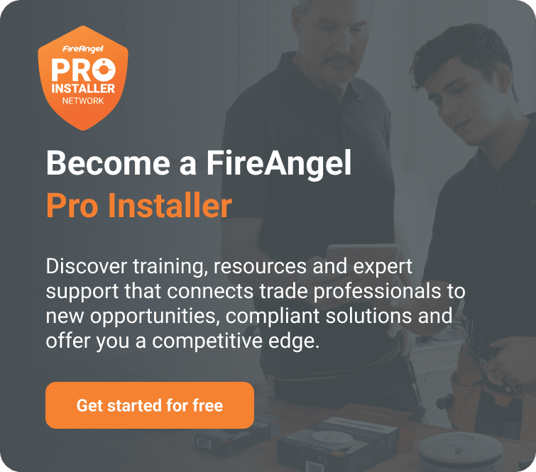 Two men work with tools by a FireAngel Pro Installer Network Connected Solutions sign.