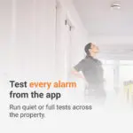 A technician looking up at a ceiling-mounted Angel Pro App smoke alarm.